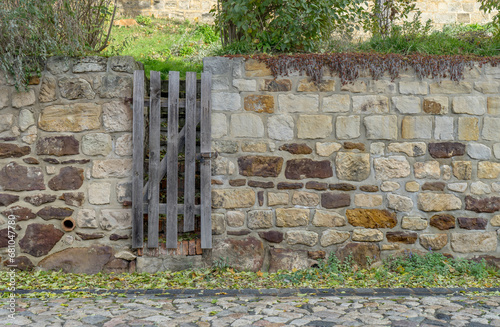 Wall on the Schlossberg in Quedlinburg made of rock stones with a narrow wooden door