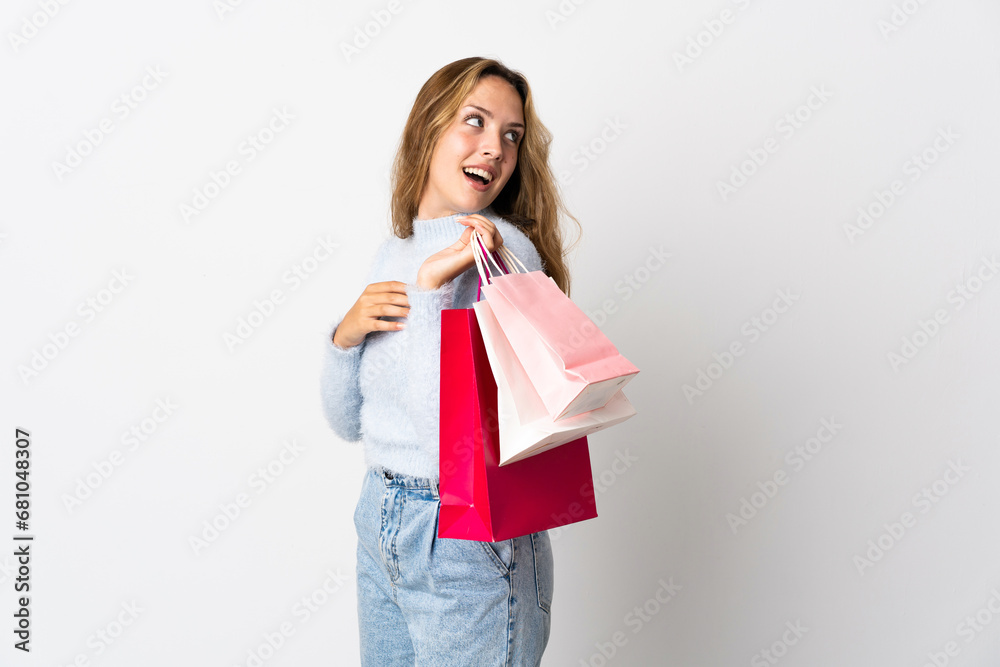 Young blonde woman isolated on white background holding shopping bags and smiling Young blonde woman isolated on white background holding shopping bags and smiling
