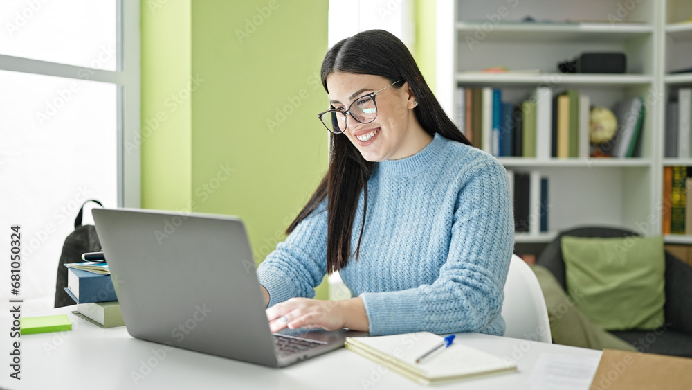 Young hispanic woman student using laptop smiling at library university Young hispanic woman student using laptop smiling at library university