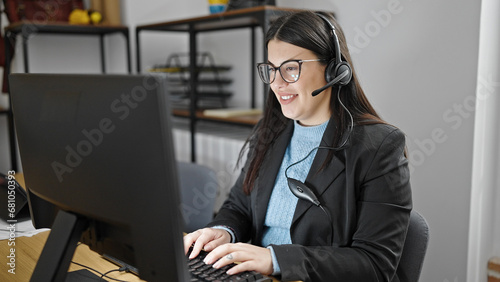 Young hispanic woman business worker using computer working wearing headset at office