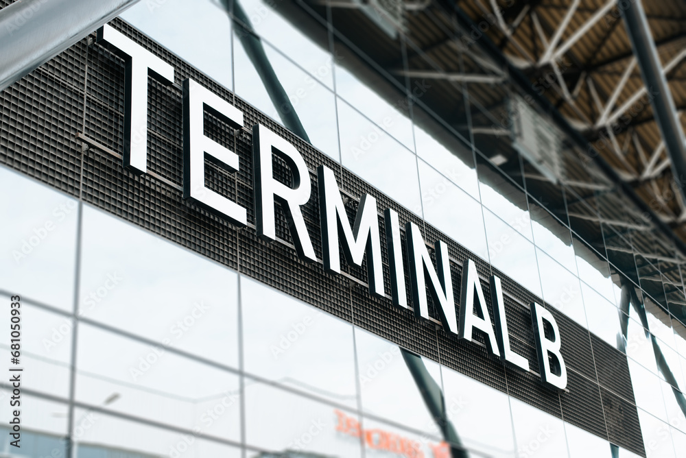 Side view of a large information sign with the text Terminal B airport building, close-up Side view of a large information sign with the text Terminal B airport building, close-up