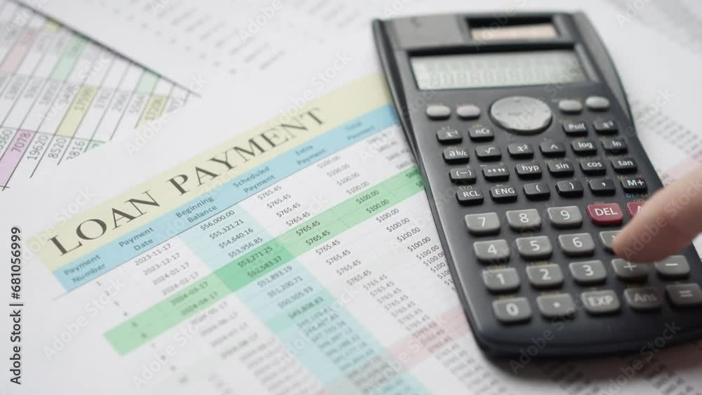 Calculating Loan Payment With Calculator Over Documents Calculating Loan Payment With Calculator Over Documents
