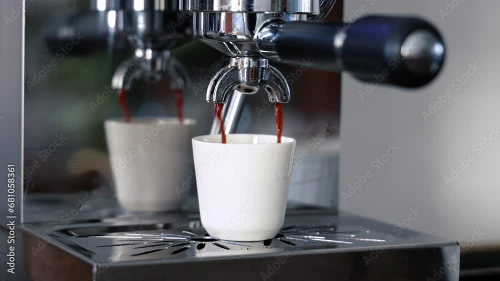 Préparation d'un espresso, café qui coule dans une tasse blanche en céramique