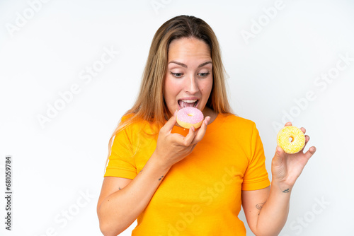 Young caucasian woman isolated on white background eating a donut