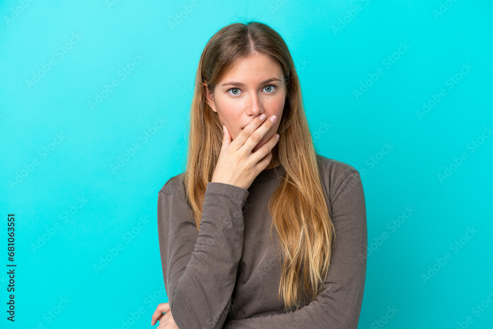 Young blonde woman isolated on blue background surprised and shocked while looking right Young blonde woman isolated on blue background surprised and shocked while looking right