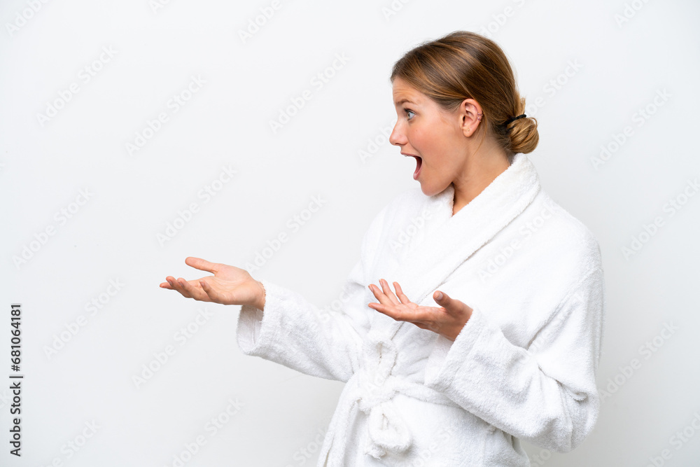 Young pretty blonde woman in bathrobe isolated on white background with surprise expression while looking side Young pretty blonde woman in bathrobe isolated on white background with surprise expression while looking side