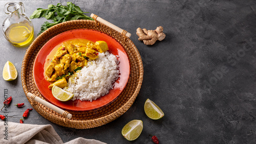 Chicken in curry sauce and rice on gray background copyspace for text, Indian food