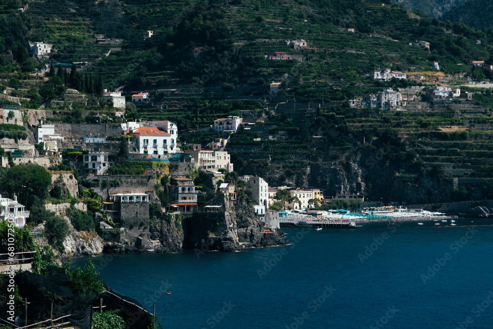 Amalfi Sea Coast with Umbrellas, people swim, and Yachts. Clean and blue sea where to swim. Photo for tourism and summer background. Concept of vacation and beach life in the open air