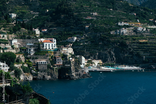 Fototapeta Naklejka Na Ścianę i Meble -  Amalfi Sea Coast with Umbrellas, people swim, and Yachts. Clean and blue sea where to swim. Photo for tourism and summer background. Concept of vacation and beach life in the open air