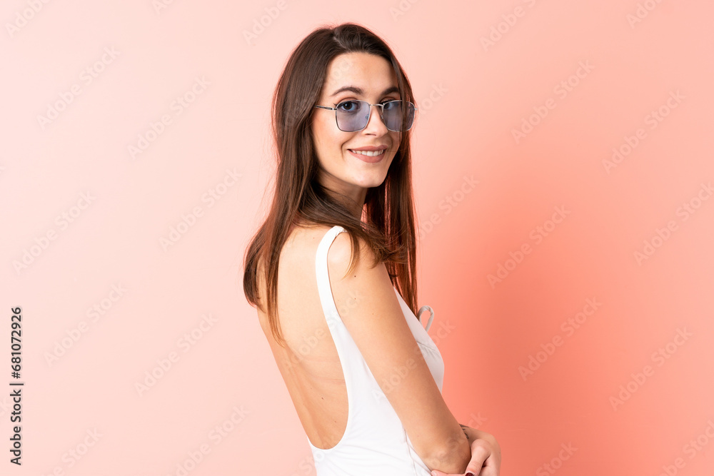 Young woman over isolated pink background in swimsuit in summer holidays Young woman over isolated pink background in swimsuit in summer holidays