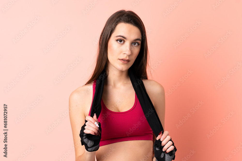 Young sport woman over isolated pink background with sport towel Young sport woman over isolated pink background with sport towel
