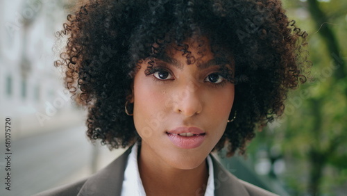 Sensual girl face looking camera with light smile close up. Portrait curly woman