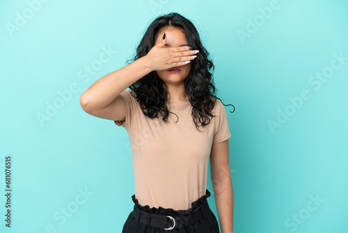 Young asian woman isolated on blue background covering eyes by hands. Do not want to see something © luismolinero