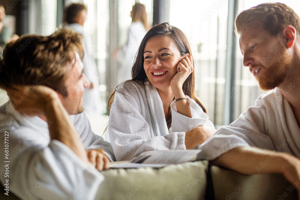 Group of happy people enjoying wellness relax weekend. Woman with two handsome men in bedroom. Group of happy people enjoying wellness relax weekend. Woman with two handsome men in bedroom.