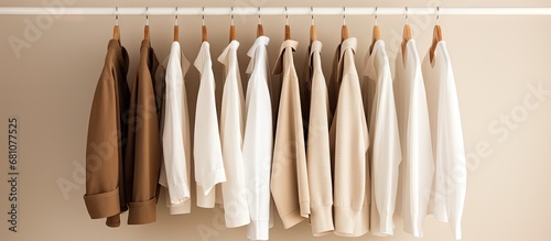 Simplified display of white and beige clothes on a rack Copy space image Place for adding text or design photo