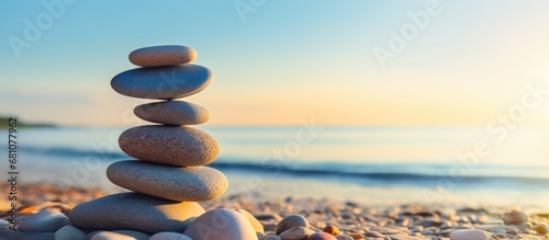 Pebbles pyramid at sunset on the beach with blue sea in the background evoking a sense of calm and harmony Copy space image Place for adding text or design