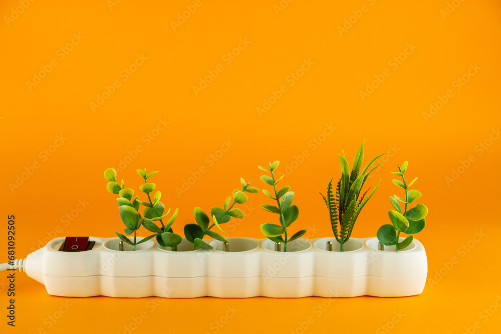 Plants in the white plastic socket on orange background. Copy space.