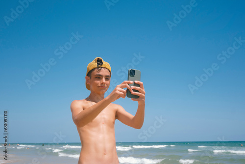 Teenage girl enjoying a fabulous day at the beach using smartphone.