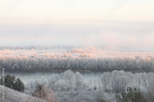 The light of the rising sun on the frost-covered trees, bushes and grass of the water meadows at the bend of the river © MIKHAIL BATURITSKII	