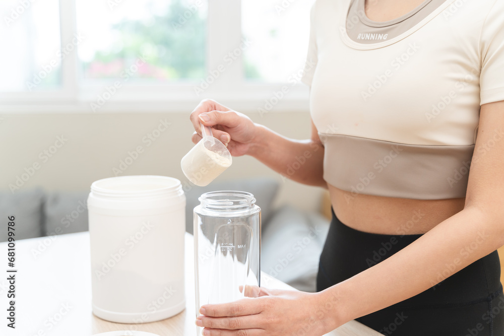 Diet meal replacement for weight loss, asian young woman in sportswear, hand in holding scoop making protein into bottle Diet meal replacement for weight loss, asian young woman in sportswear, hand in holding scoop making protein into bottle