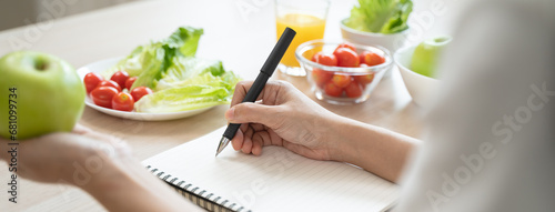 Wellbeing of health with good food control concept. Woman writing the meal note and plan to eat during diet program to loss weight goal for balance nutrition and calories.