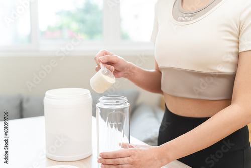 Diet meal replacement for weight loss, asian young woman in sportswear, hand in holding scoop making protein into bottle