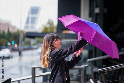 Opening umbrella, brown-haired beauty, Madrid rain.