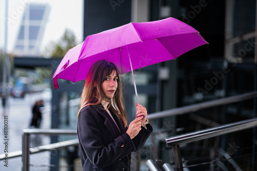 Madrid skyline, umbrella, brown-haired beauty, urban chic, glass buildings, rain.