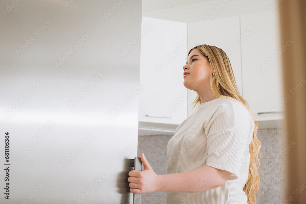 Happy young woman standing at the opened fridge. Happy young woman standing at the opened fridge.