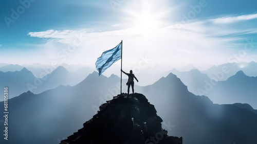 Silhouette of man holding blue flag on top of mountain, achievement and success concept photo