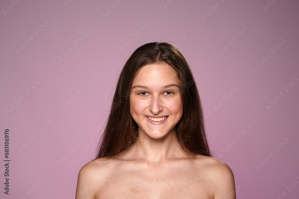 Portrait of young seminude woman in studio on pink background close up. Woman smiling looking straight ahead. Concept of beauty, cosmetology, skin care. Portrait of young seminude woman in studio on pink background close up. Woman smiling looking straight ahead. Concept of beauty, cosmetology, skin care.
