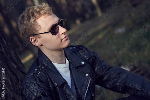 Young male in leather jacket portrait in sunglasses