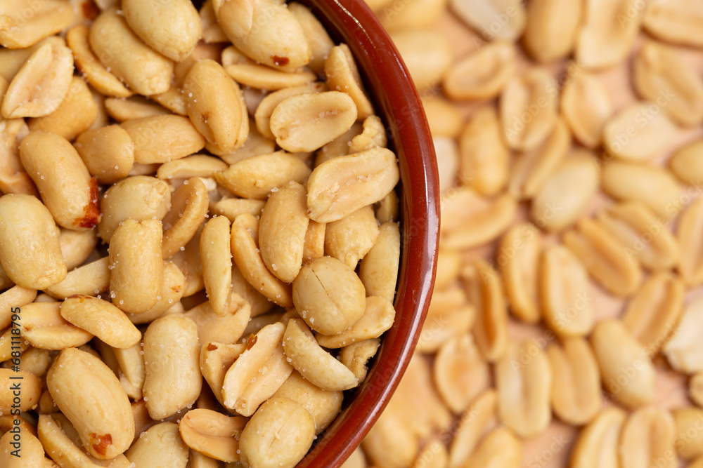 Peeled roasted peanuts close-up. Salted peanuts in bowl in selective focus and out of focus, top view. Peeled roasted peanuts close-up. Salted peanuts in bowl in selective focus and out of focus, top view.