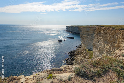 Cape Tarkhankut on the Crimean peninsula. The rocky coast of the Dzhangul Reserve in the Crimea. The Black Sea. Turquoise sea water. Rocks and grottoes of Cape Tarkhankut. photo