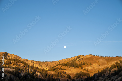 Photography Moon rising over the mountains near Dubois, Wyoming at dusk