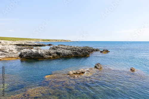 Cape Tarkhankut on the Crimean peninsula. The rocky coast of the Dzhangul Reserve in the Crimea. A sunny summer day. The Black Sea. Turquoise sea water. photo