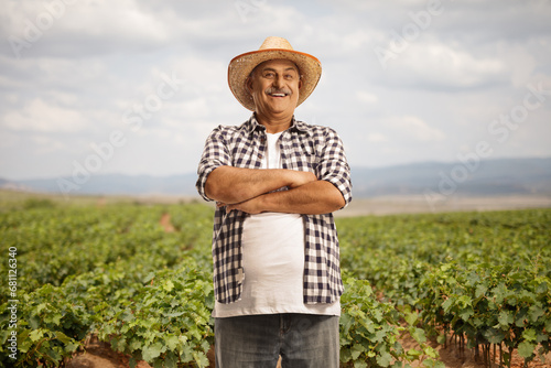 Foto Mature farmer posing with crossed arms at a vineyard
