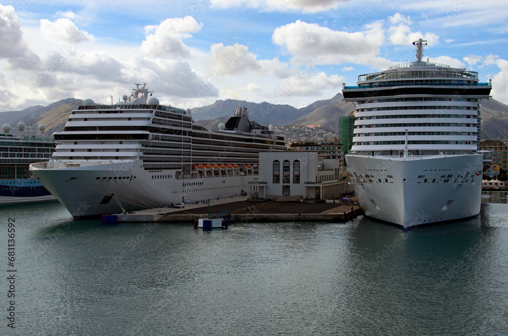 Obraz premium Close-up view two moored luxury cruise liners in harbor of Palermo. Cityscape and mountain range in the background. Colorful vibrant sky. Travel and tourism concept