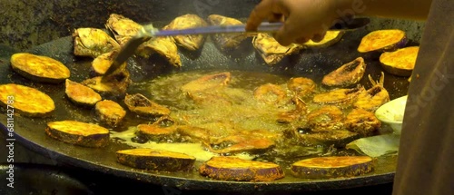 person frying hilsha fish in an asian restaurent photo