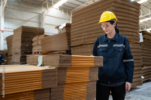 Caucasian businesswoman checking Kraft paper stock in warehouse 