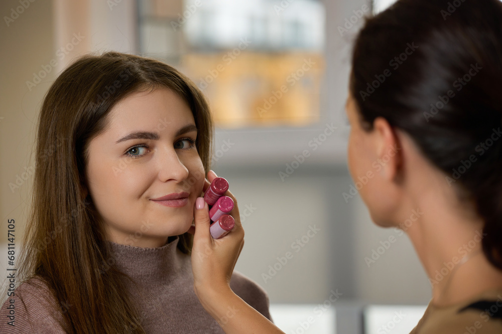 Selection of the right lip shade for future permanent makeup. Young beautiful brunette girl chooses a shade for lip tattooing Selection of the right lip shade for future permanent makeup. Young beautiful brunette girl chooses a shade for lip tattooing