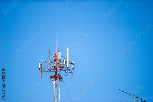 Telecommunication tower with blue sky and white clouds, technology background. photo