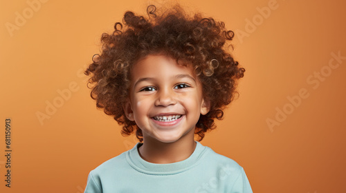 Portrait of a smiling child with curly hair against a warm background, illustrating oral health and joy.