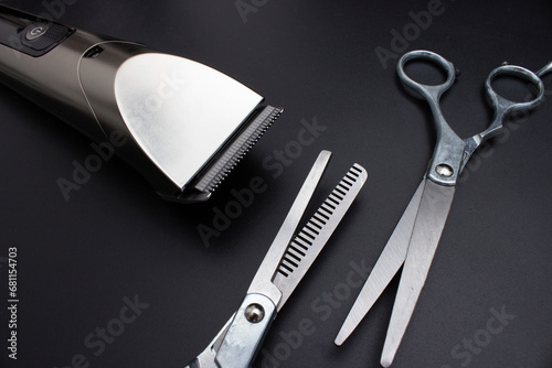 Hairdressing scissors and Machine for a hairstyle on black background. Male haircut, fashion. Hairdresser salon equipment concept, premium hairdressing shears. Accessories for haircut