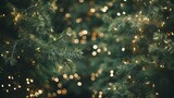 Christmas tree banner with a garland of lights on a blurred background, merry Xmas green branches shiny background with copy space.