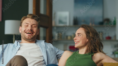 Closeup laughing couple resting sofa home. Cheerful carefree spouses having fun