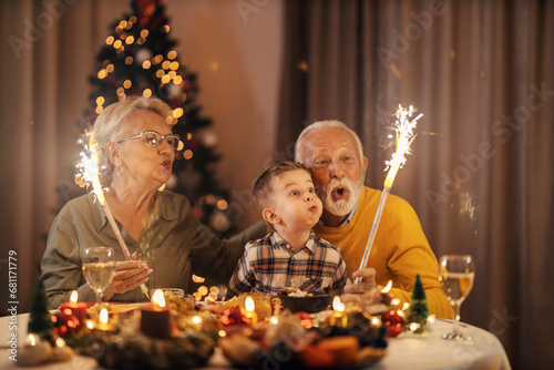 Photography Grandparents are celebrating christmas and new year's eve at christmas table and playing with fireworks on christmas and new year's eve