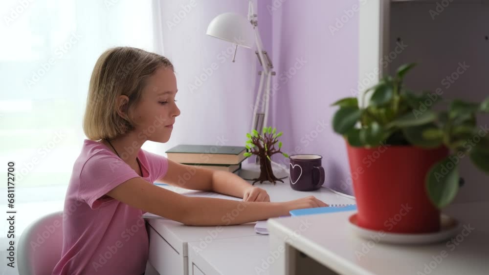 Diligent little girl doing homework at her desk, distance learning and