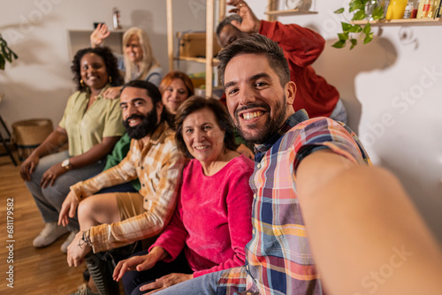 group family friends multigeneration multiracial make selfie with smart phone in the living room at home on the sofa © PintoArt