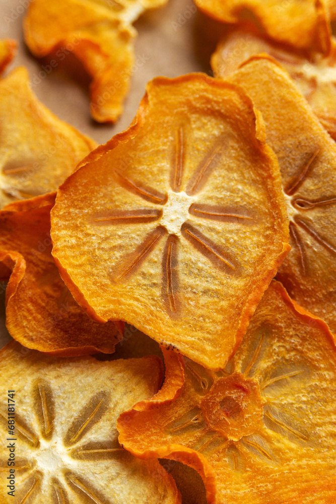 Many dry orange persimmon slices, close-up. Healthy fruit snacks. Many dry orange persimmon slices, close-up. Healthy fruit snacks.